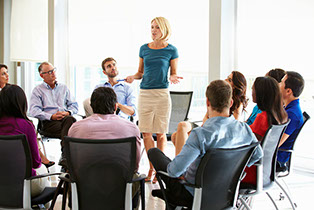 Image of woman addressing a group of interested business persons.